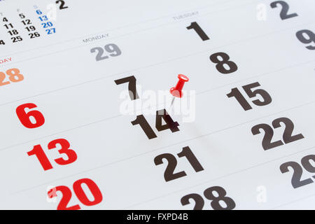 Pin pushed on a calendar concept for an important day. Stock Photo