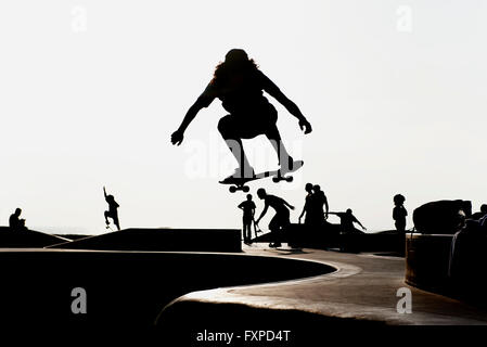 Skateboarder at skate park, silhouetted Stock Photo