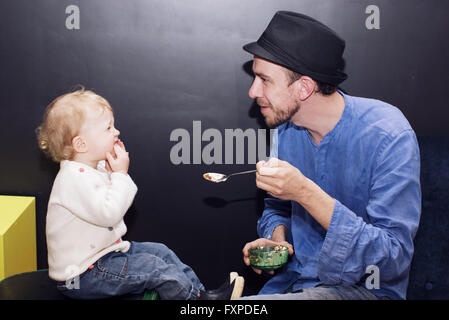 Father feeding toddler Stock Photo