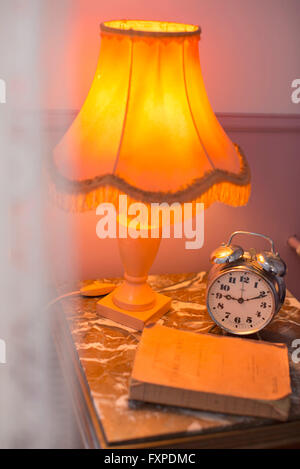 Lamp, alarm clock on bedside table Stock Photo