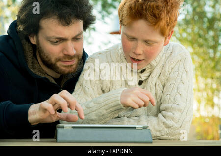Father and son looking at digital tablet together Stock Photo