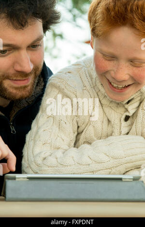 Father and son using digital tablet together Stock Photo