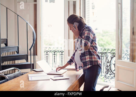 Pregnant woman working from home Stock Photo