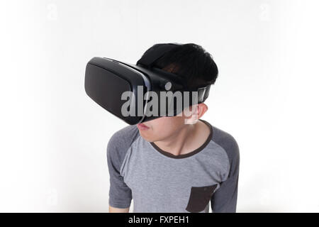 Asian man wearing VR goggle and immersing himself in VR multimedia in white isolated. Stock Photo