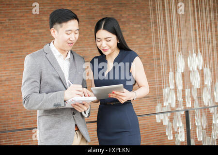 Asian businessman and business woman having a casual business conversation Stock Photo