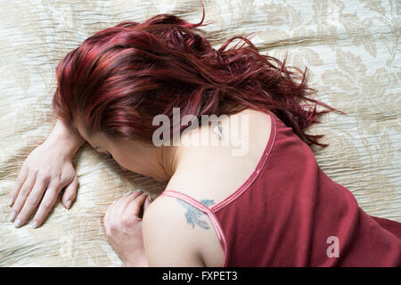 Sad redhead woman in bed Stock Photo