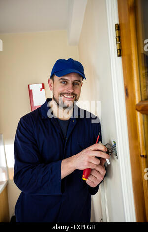 Portrait of electrician fixing a door bell Stock Photo