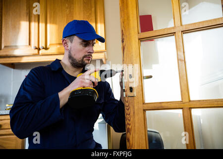 Manual worker drilling a hole in kitchen Stock Photo