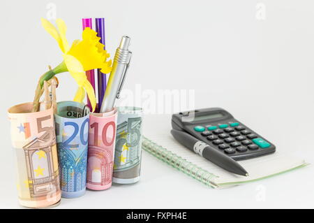 Finance abstract with euro bills as a pen holder, calculator and a notebook Stock Photo