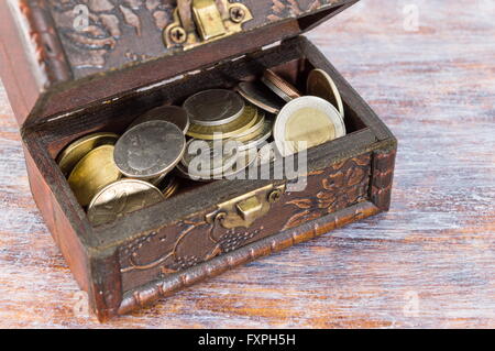 Metal coins in an old wooden box Stock Photo