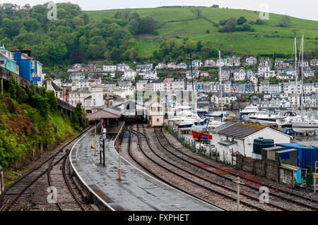 A fine mist shrouds the green fields above the attractive houses of Dartmouth and across the river the station platform glistens Stock Photo