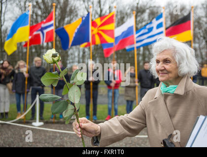 Weimar, Germany. 17th Apr, 2016. Former Buchenwald inmate Eva Fahidi-Pusztai from Hungary holds a flower in her hand at the concentration camp memorial on occasion of the 71th anniversary of its liberation that occured on 11 April 1945, in Weimar, Germany, 17 April 2016. A permanent exhibition which was reopened on the same day spans 2,000 square metres and outlines the history of the concentration camp. Photo: MICHAEL REICHEL/dpa/Alamy Live News Stock Photo