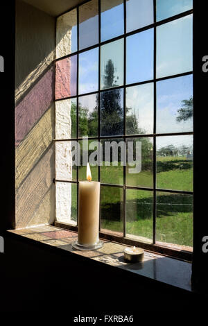 Burning candles in a window Stock Photo