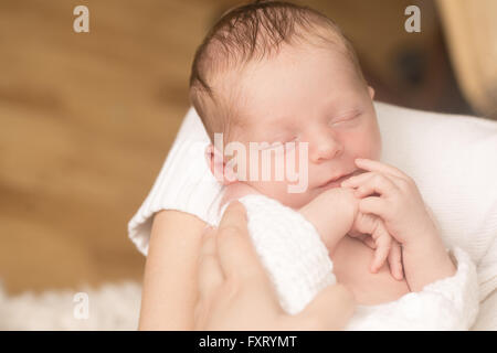 Newborn baby sleeping on sheet Stock Photo