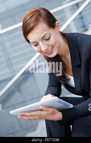 Businesswoman sitting with Digital Tablet Computer on stairs Stock Photo