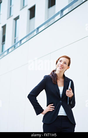 Happy business woman standing in front of a university Stock Photo