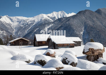 Barns in the snow in front of the Karwendel Mountains, near Mittenwald, Werdenfelser Land, Upper Bavaria, Bavaria, Germany Stock Photo