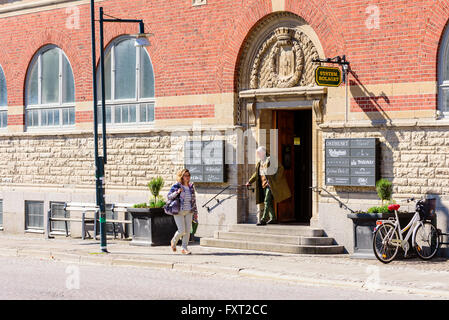 Lund, Sweden - April 11, 2016: Everyday life in city. One of the entrances to the indoor market in town. Two persons outside, on Stock Photo