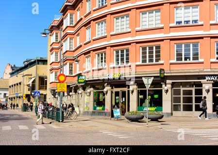 Lund, Sweden - April 11, 2016: Everyday life in the city. Here a street corner where Subway has a shop or eatery. People walk by Stock Photo