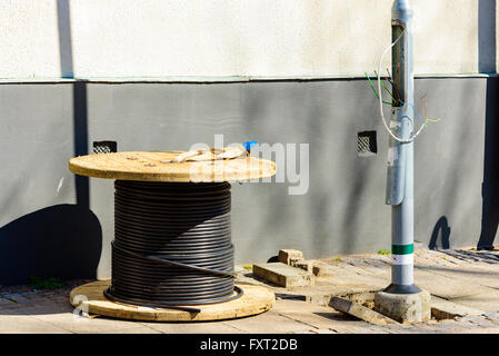 Lund, Sweden - April 11, 2016: Electric cable drum or spool, outdoors with black cable rolled up on it. Stock Photo