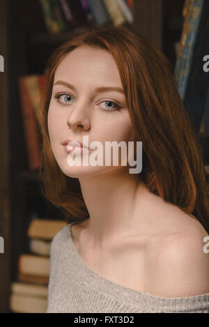 Young red-haired woman wearing a grey jumper, portrait Stock Photo