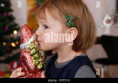 Side view of girl kissing christmas ornament of santa Stock Photo