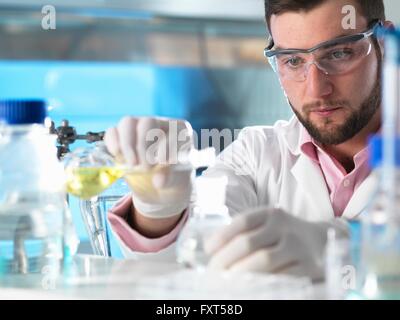 Scientist experimenting with chemical formula in laboratory Stock Photo