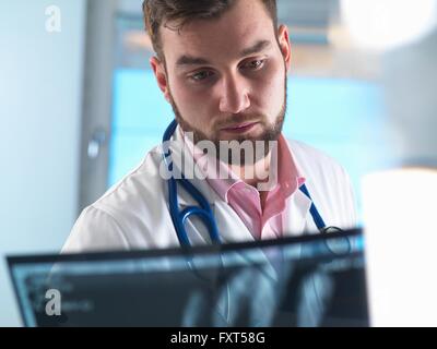 Junior doctor examining x-ray of fractured hand in hospital Stock Photo