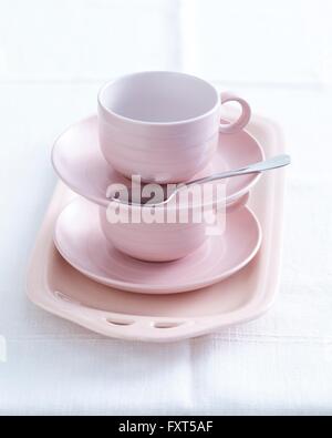 Pink cups and saucers stacked on dish preparing for high tea Stock Photo
