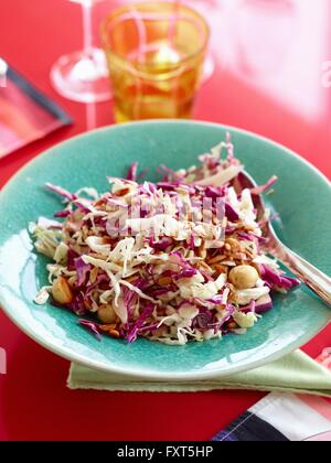 High angle view of red and white cabbage salad with macadamia nuts in blue bowl Stock Photo