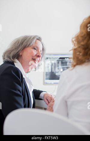 Senior woman discussing x-ray image on computer screen Stock Photo