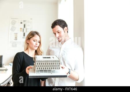 Colleagues in office holding architectural model Stock Photo