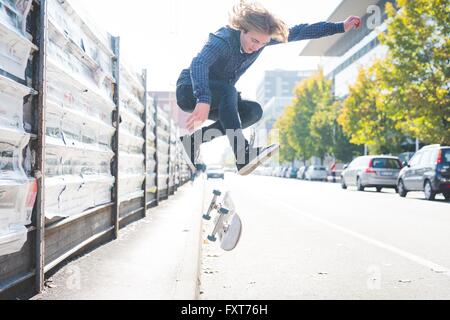 Young male urban skateboarder doing skateboard jump  on road Stock Photo