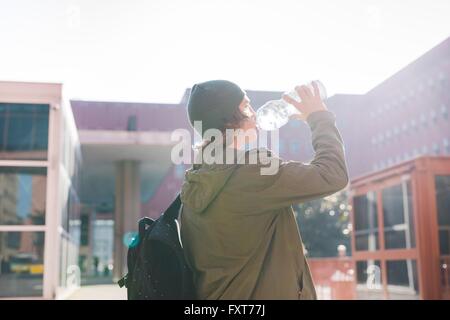 Young urban man drinking from bottle of water Stock Photo