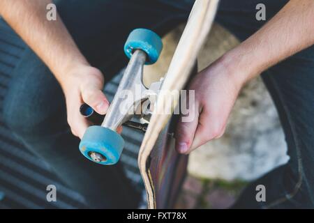 Cropped shot of man sitting holding skateboard Stock Photo