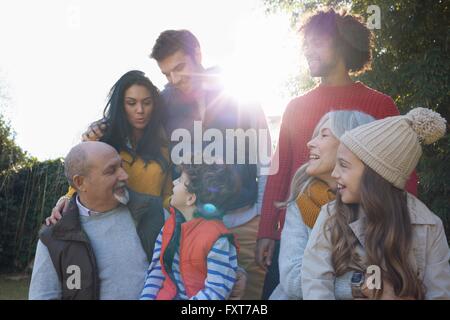 Multi generation family huddled together chatting and smiling Stock Photo