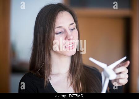 Young woman holding model wind turbine Stock Photo