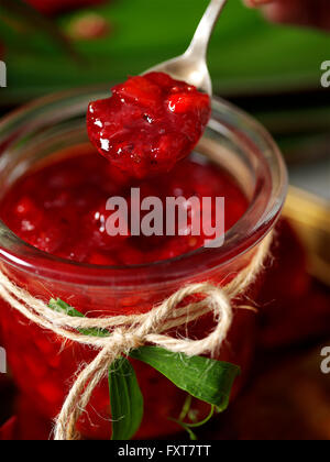 Jar of homemade redcurrant jam and spoon Stock Photo