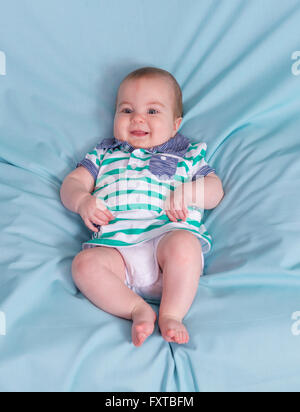 Adorable happy baby boy on blue background.Focus on the face Stock Photo