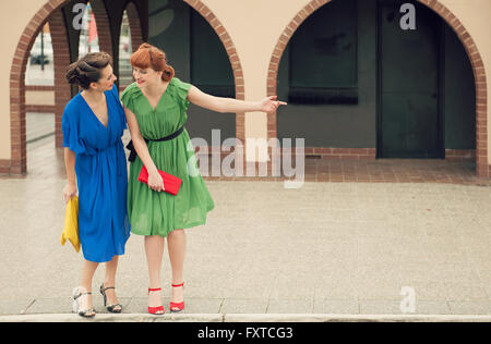 Two beautiful girls on the street in retro style.Urban scene with young women Stock Photo