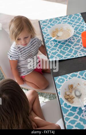High angle view of sisters at dining table eating breakfast Stock Photo