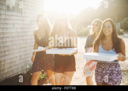 Women carrying pizza boxes smiling Stock Photo