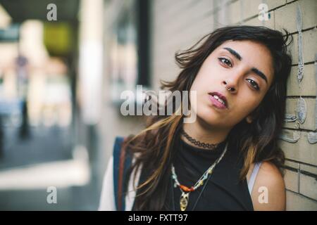 Woman with nose ring leaning against wall looking at camera, Boston, Massachusetts, USA Stock Photo