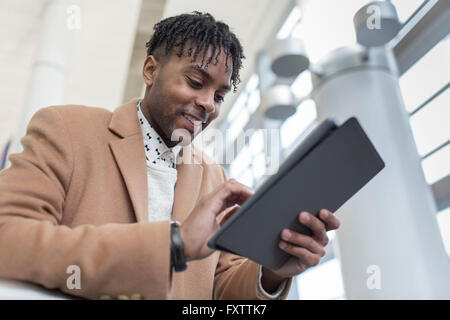 Young businessman in train station using digital tablet touchscreen Stock Photo