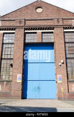Very tall wooden garage doors at the entrance to an old bus depot in Birmingham Stock Photo