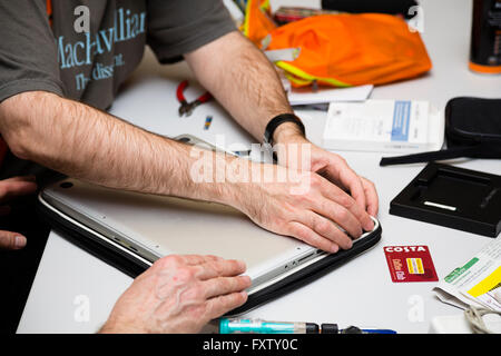 Hackney, London, UK. Detail view of Restart Party volunteer David Mery removing the base of an Apple MacBook Pro. Stock Photo