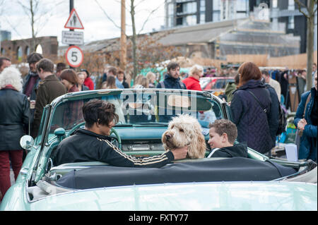 Two kids sitting in a classic car with their dog, posing for people at the Classic car boot sale in Cubitt Square, Kings Cross Stock Photo
