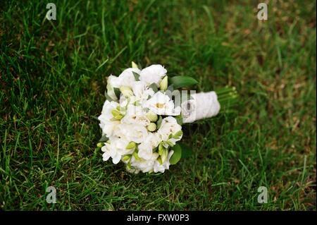 white bridal wedding bouquet on the green grass