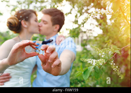 bride and groom holding rings Stock Photo