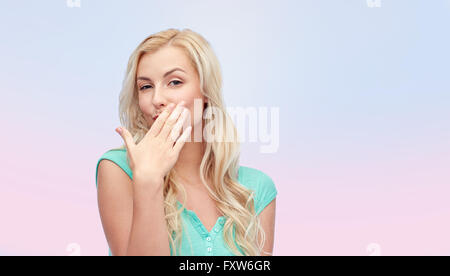 smiling young woman or teen girl covering mouth Stock Photo